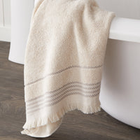 Jude Fringe Bath Towel, Beige, displayed on side of bath tub