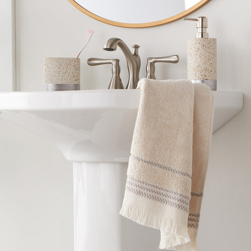 Jude Fringe Hand Towel, Beige, displayed on side of sink